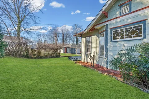 a view of a house with a yard and pathway