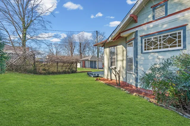 a view of a house with a yard and pathway