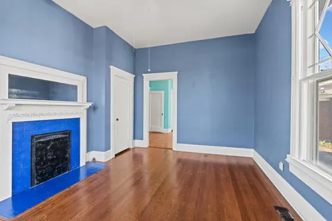 a view of empty room with wooden floor and fireplace