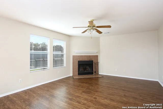 a view of an empty room with a fireplace and a window
