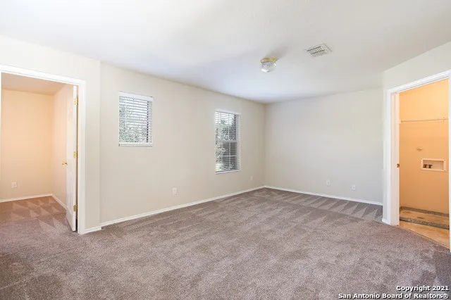 an empty room with windows and closet