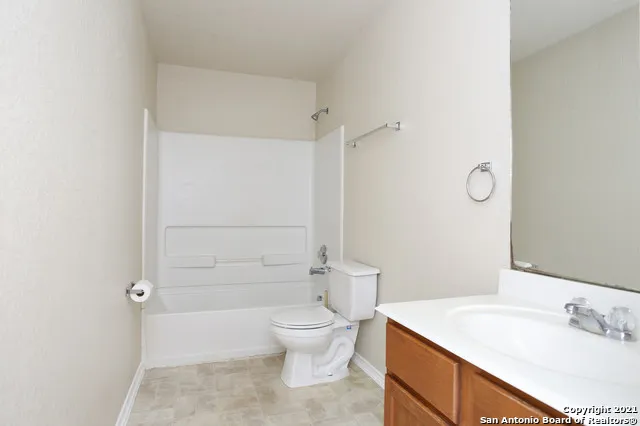 a bathroom with a granite countertop sink toilet a mirror and shower