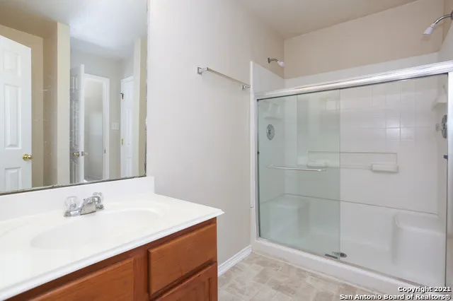 a bathroom with a shower sink and mirror