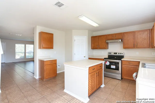 a kitchen with stainless steel appliances granite countertop a stove a sink and a refrigerator