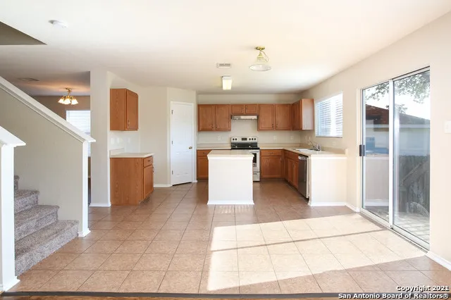 a kitchen with stainless steel appliances granite countertop a refrigerator and a stove top oven
