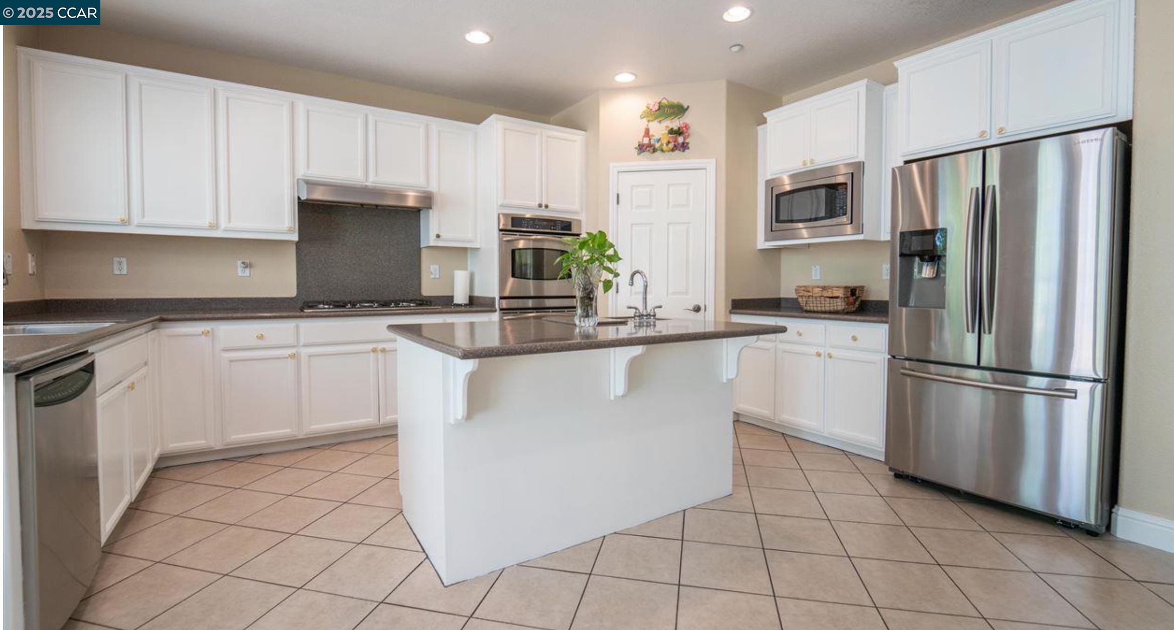1849 Alexander Way Brentwood, CA 94513 - Photo 17 of 38 a kitchen with white cabinets stainless steel appliances and sink