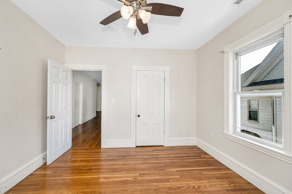 85 Sherman Street, Unit 3 Lowell, MA 01852 - Photo 5 of 11 a view of an empty room with wooden floor and a window