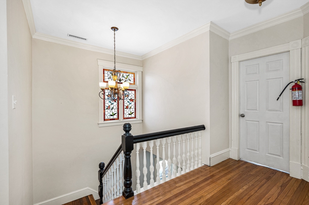 85 Sherman Street, Unit 3 Lowell, MA 01852 - Photo 6 of 11 a view of a hallway with wooden floor and stairs