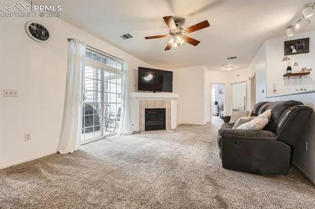 a living room with furniture a flat screen tv and a fireplace