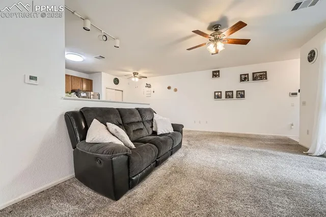 a living room with furniture and a ceiling fan