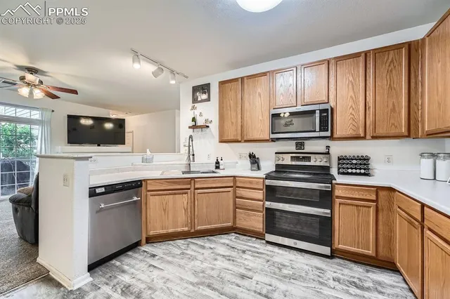 a kitchen with stainless steel appliances granite countertop a stove top oven a sink dishwasher and a microwave oven on the blue kitchen countertops