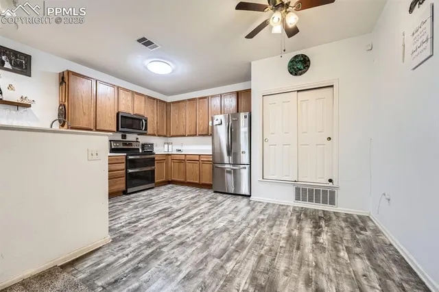 a kitchen with stainless steel appliances granite countertop a refrigerator sink and stove
