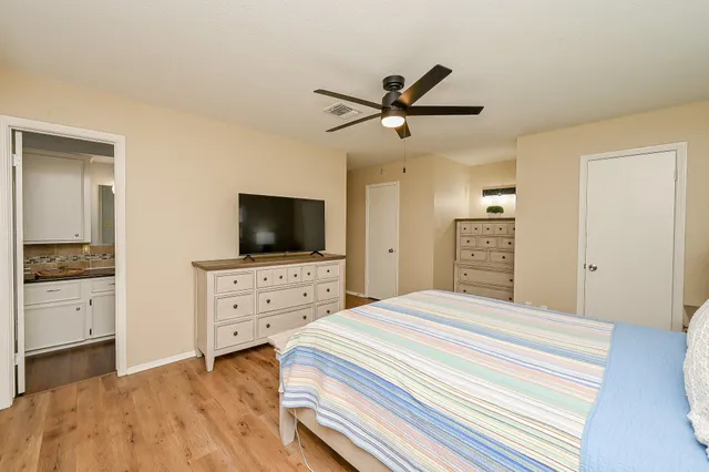 a bedroom with a bed and a flat tv screen on the dresser