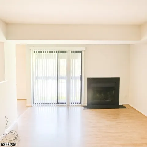 a view of an empty room with a fireplace and a window