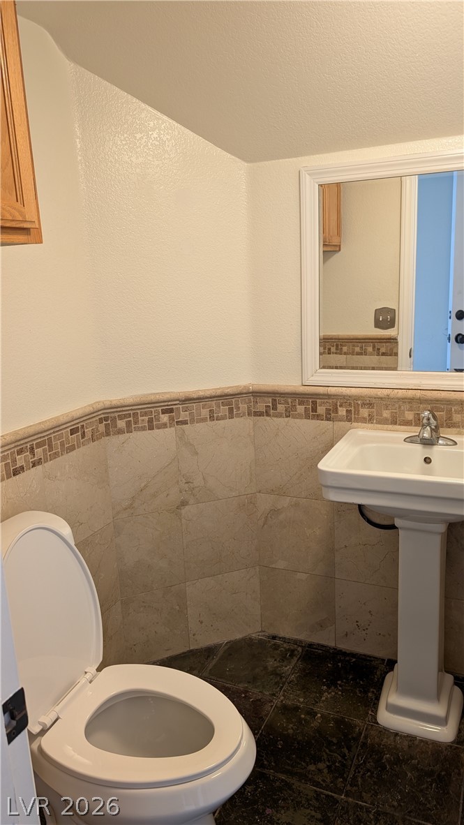 2670 Ridgewater Circle Henderson, NV 89074 - Photo 9 of 22 This bathroom features a classic pedestal sink and elegant tilework, creating a stylish and functional space.