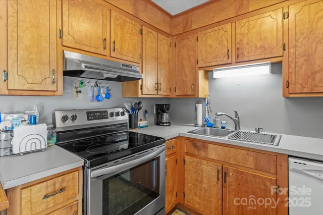 a kitchen with stainless steel appliances granite countertop a sink a stove and cabinets