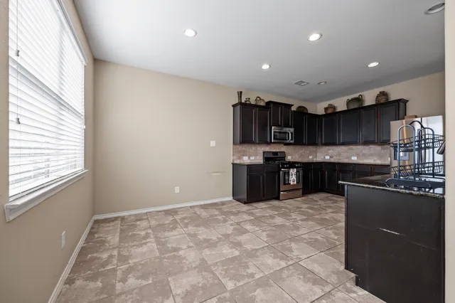 a kitchen with stainless steel appliances granite countertop a stove top oven a sink and a granite counter tops