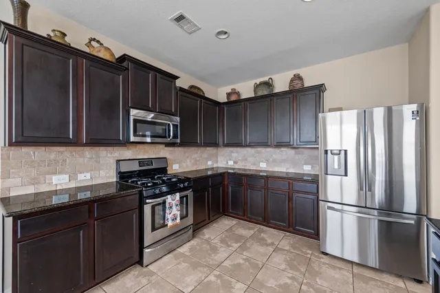 a kitchen with stainless steel appliances granite countertop a refrigerator stove a sink and dishwasher