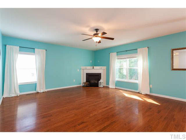 Spacious family room with fireplace and ceiling fan. Great open space that will accommodate any furniture.