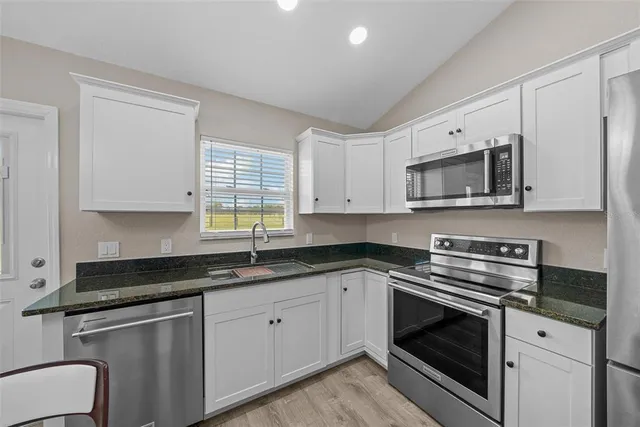 a kitchen with a sink window and cabinets