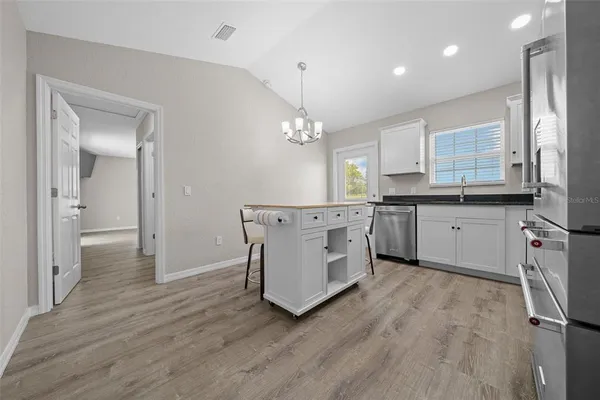 a kitchen with kitchen island granite countertop wooden floors and stainless steel appliances