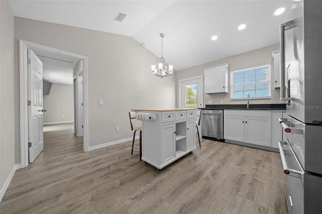 a kitchen with kitchen island granite countertop wooden floors and stainless steel appliances