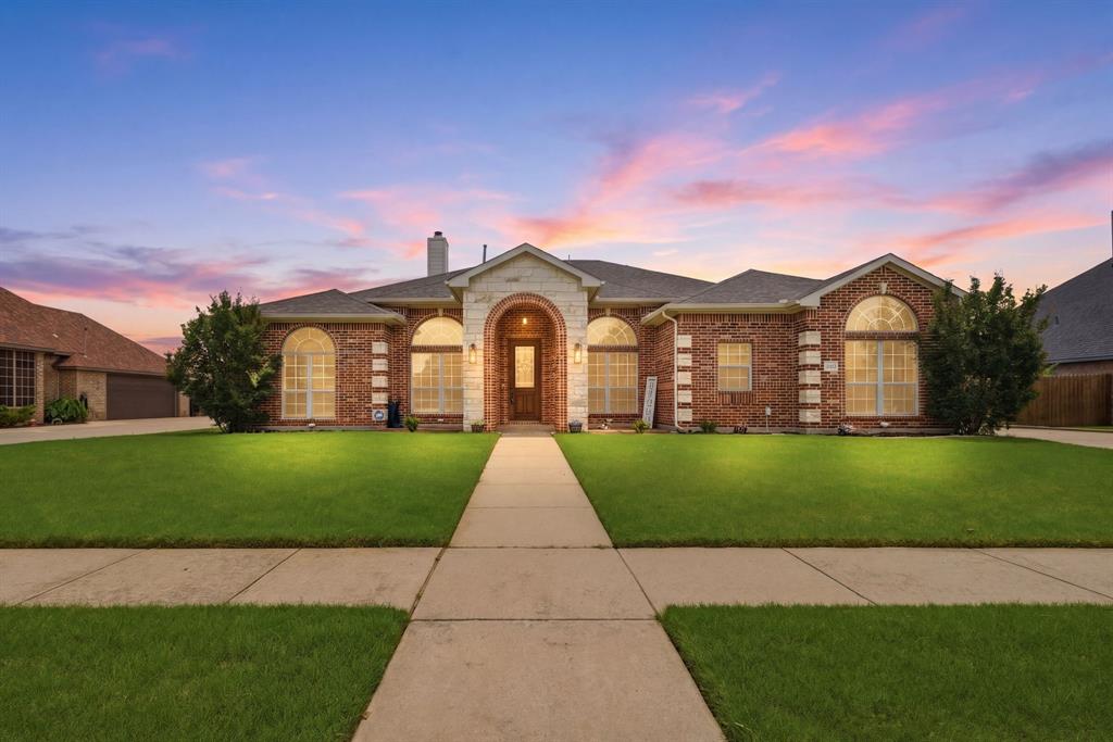 Brick and stone facade residence featuring an arched portico entryway