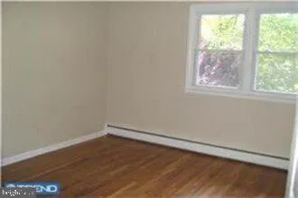 a view of a small space with wooden floor and a window
