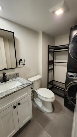 a bathroom with a granite countertop toilet sink and mirror