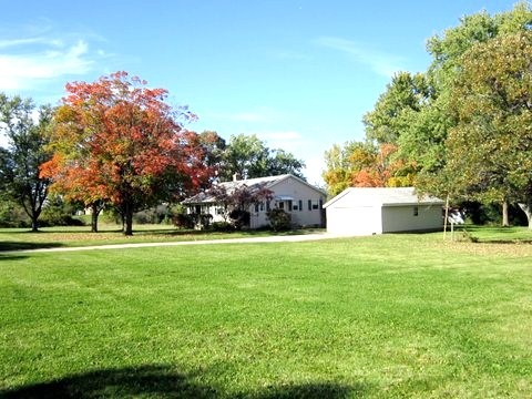 a front view of a house with a garden and trees