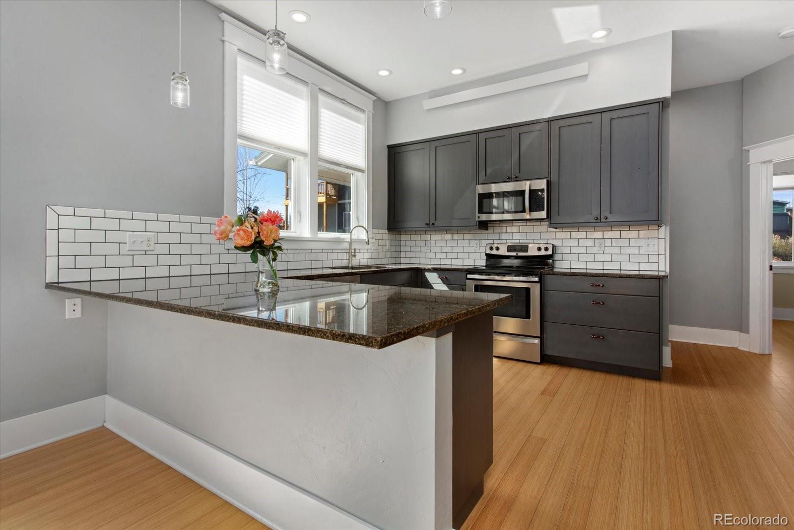 1208 E Street Salida, CO 81201 - Photo 12 of 50 a kitchen with stainless steel appliances granite countertop a sink and a stove