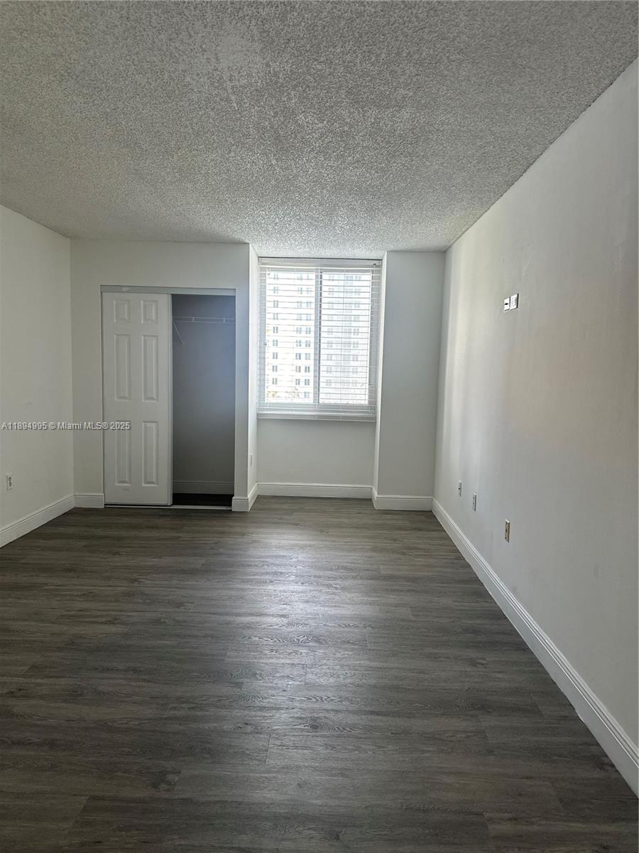 850 North Miami Avenue, Unit 810 Miami, FL 33136 - Photo 14 of 19 an empty room with wooden floor and windows