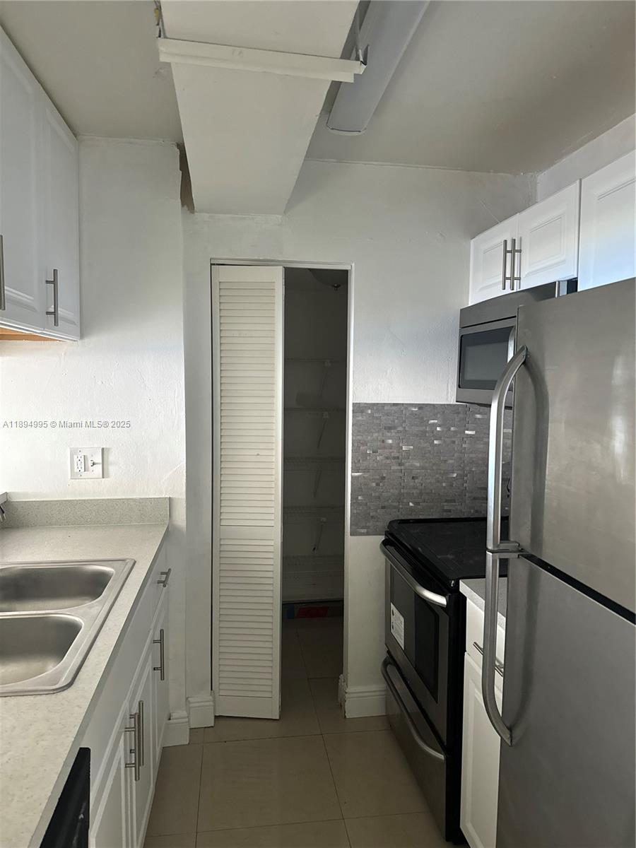 850 North Miami Avenue, Unit 810 Miami, FL 33136 - Photo 4 of 19 a kitchen with stainless steel appliances granite countertop a refrigerator and a sink
