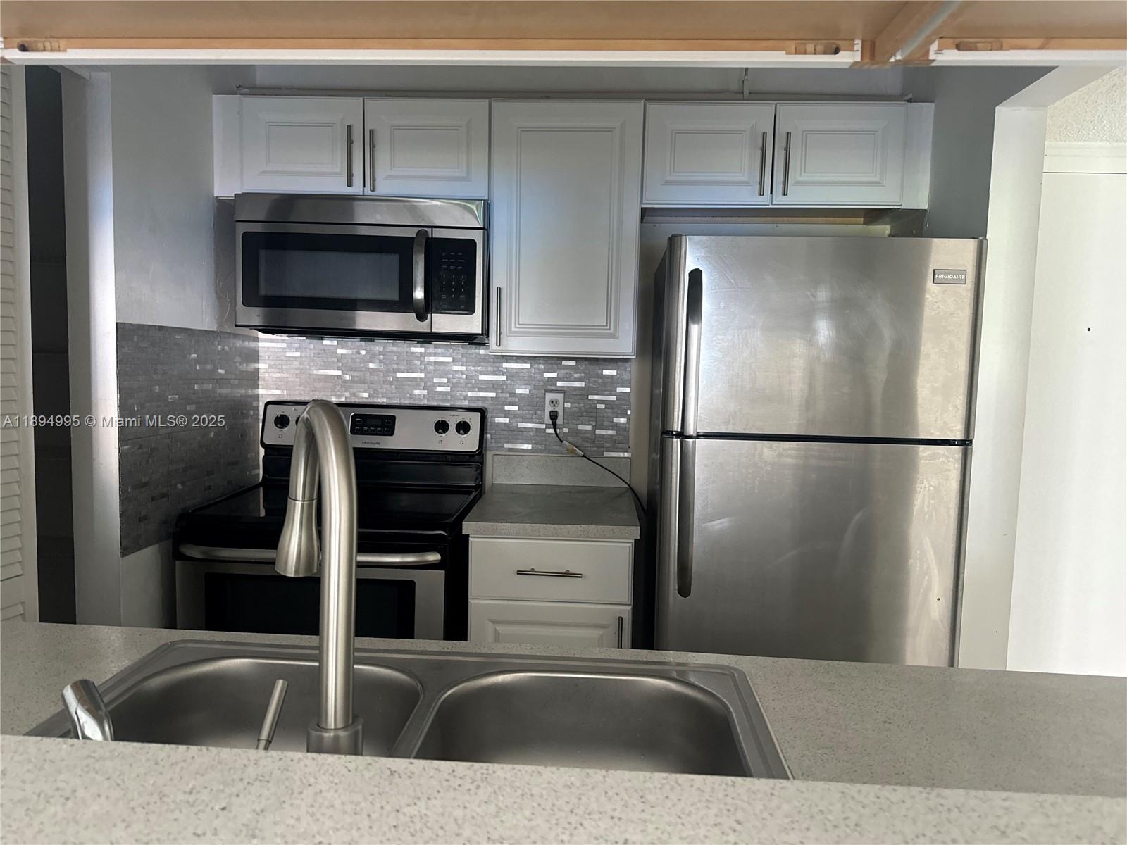 850 North Miami Avenue, Unit 810 Miami, FL 33136 - Photo 5 of 19 a kitchen with stainless steel appliances granite countertop a refrigerator and a stove top oven