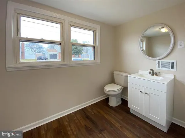 a bathroom with a toilet a sink and a window
