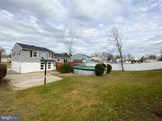 a swimming pool with lawn chairs and iron fence