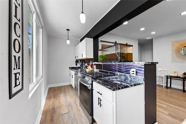 a kitchen with stainless steel appliances granite countertop a stove and cabinets