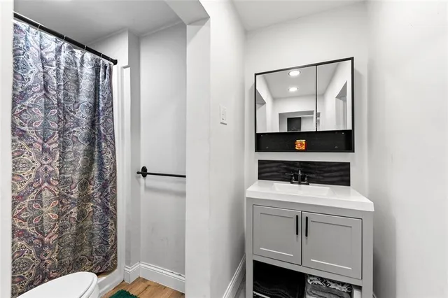 a bathroom with a sink a toilet and shower