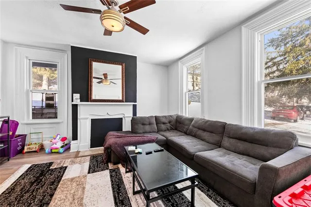 a living room with furniture a fireplace and a window