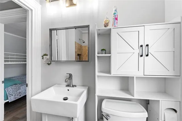 a bathroom with a sink vanity mirror and toilet