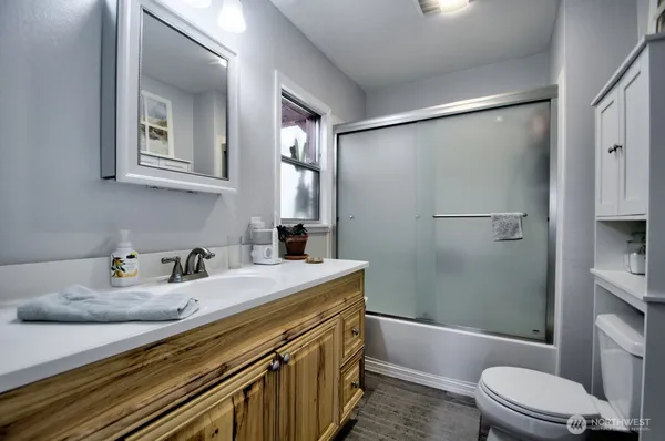 a bathroom with a sink a toilet and shower