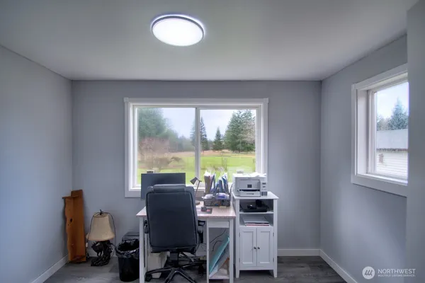 a view of a workspace with furniture and a window
