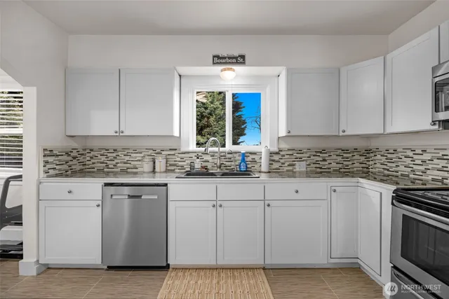 a kitchen with granite countertop white cabinets and white stainless steel appliances