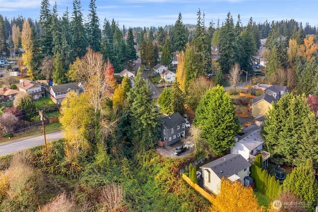 an aerial view of residential houses with outdoor space and lake view