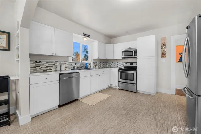 a kitchen with stainless steel appliances granite countertop a refrigerator and a stove top oven