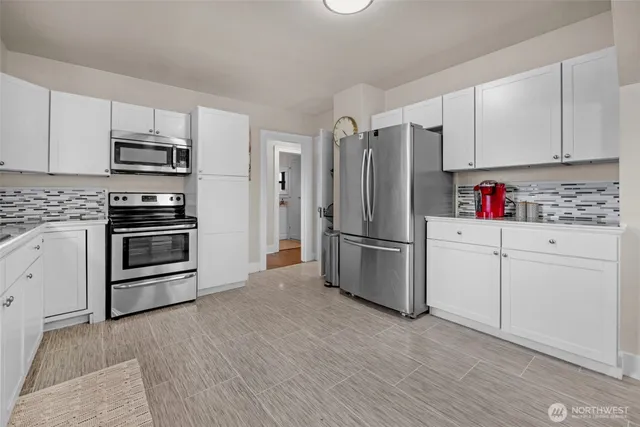 a kitchen with stainless steel appliances and white cabinets