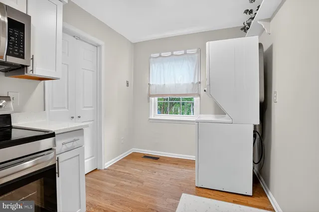 a kitchen with white cabinets and black appliances