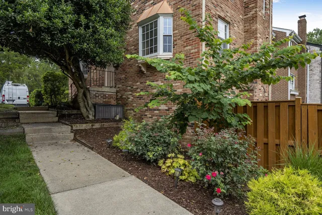 a view of a pathway of a house with a flower garden