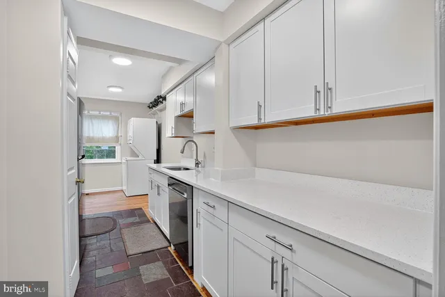 a kitchen with granite countertop white cabinets and white appliances