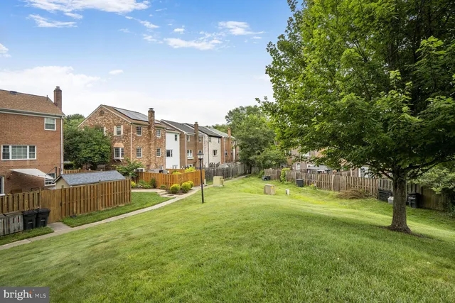 a view of a house with a big yard and large trees